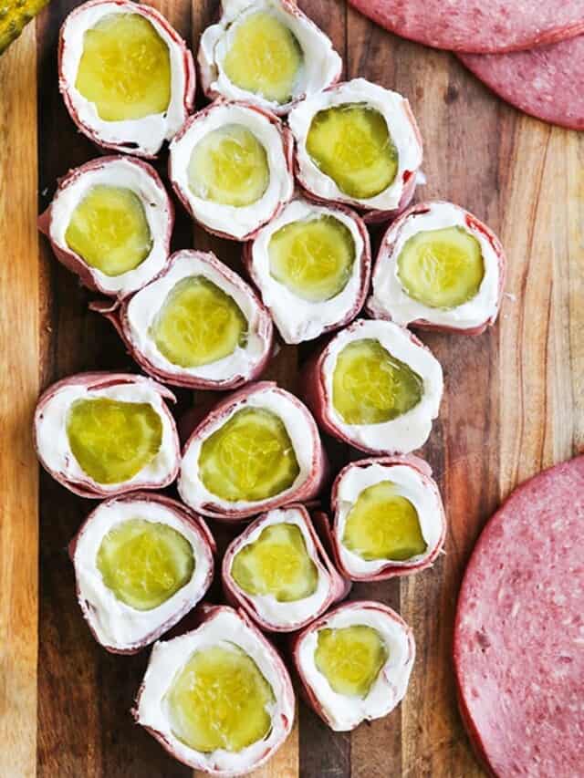 Pickle rollups lined up on a cutting board.