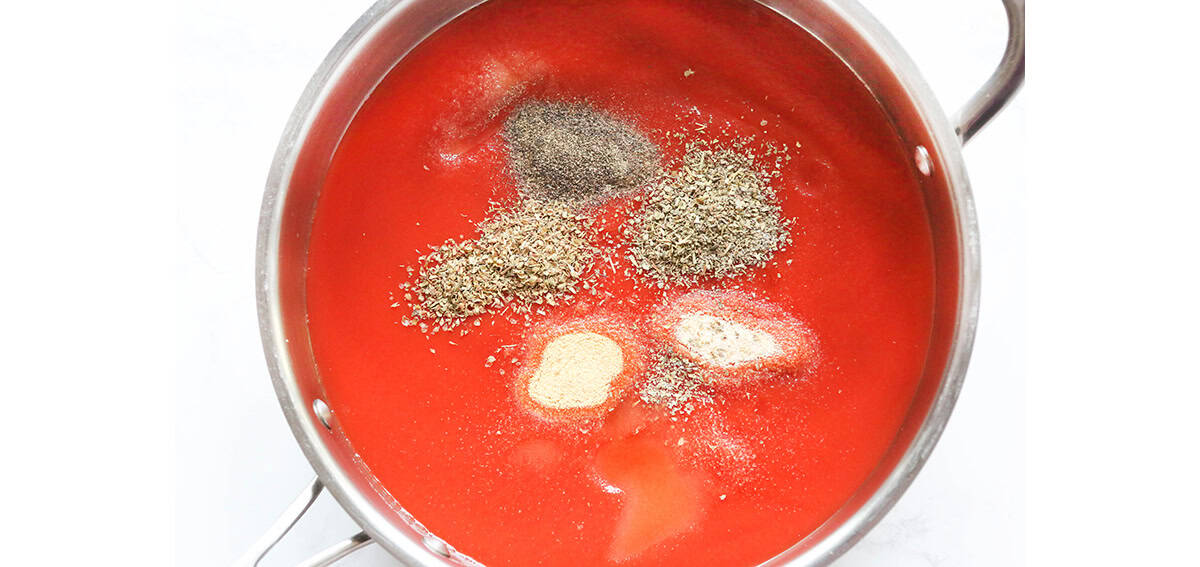Simmering tomato sauce with garlic and herbs in a saucepan.