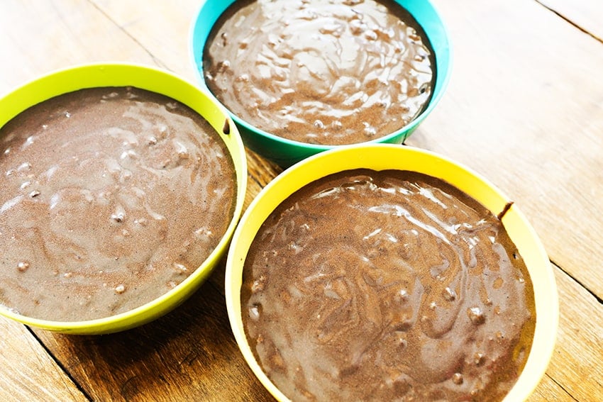 three plastic bowls holding chocolate cake batter