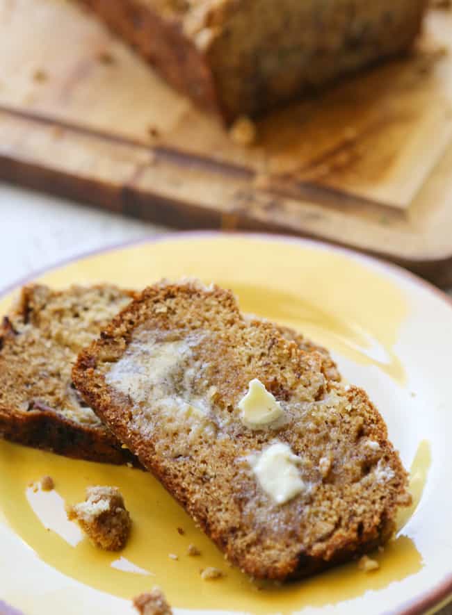 two slices of banana bread on a plate with butter melting into them