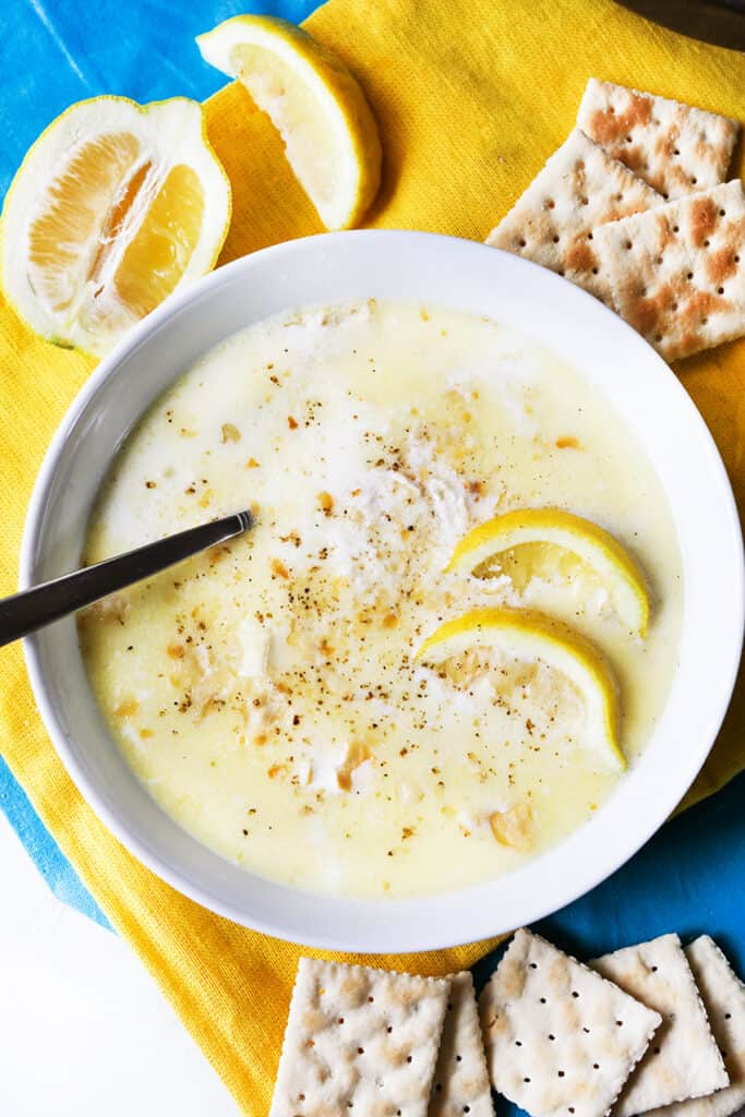 top view of bowl of crab soup with lemon wedges and saltines