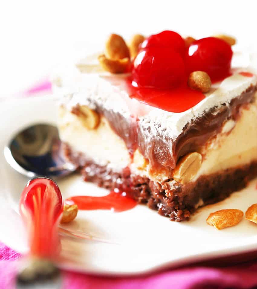 close of of a piece of buster bar ice cream cake with cherries on top