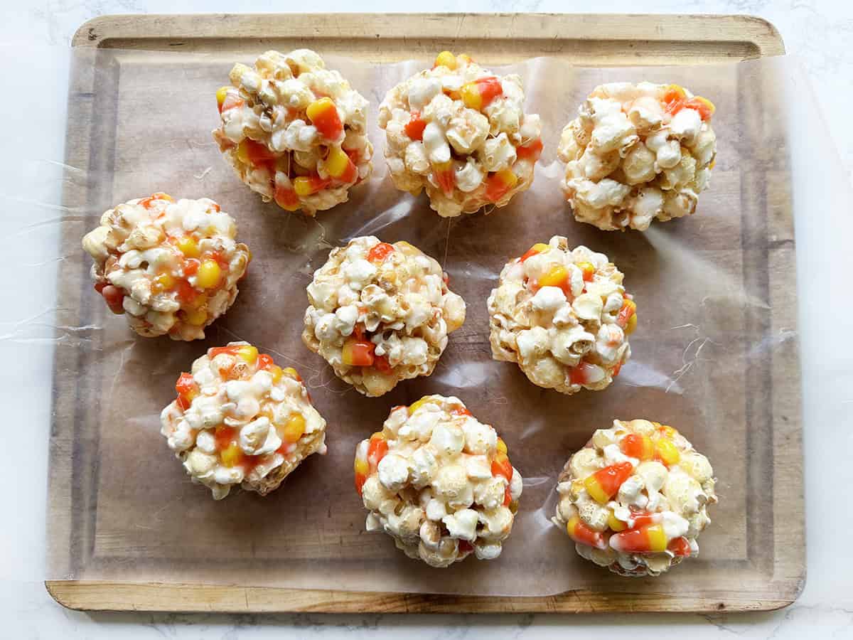 Nine popcorn balls on wax paper.