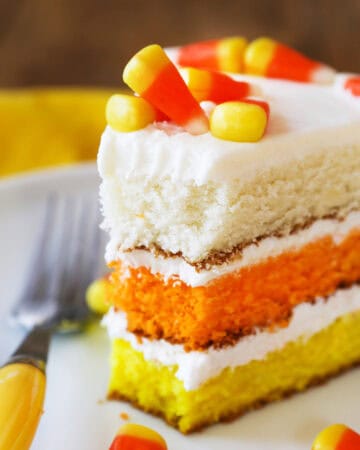 Festive Halloween candy corn layered cake with white, orange, and yellow layers.