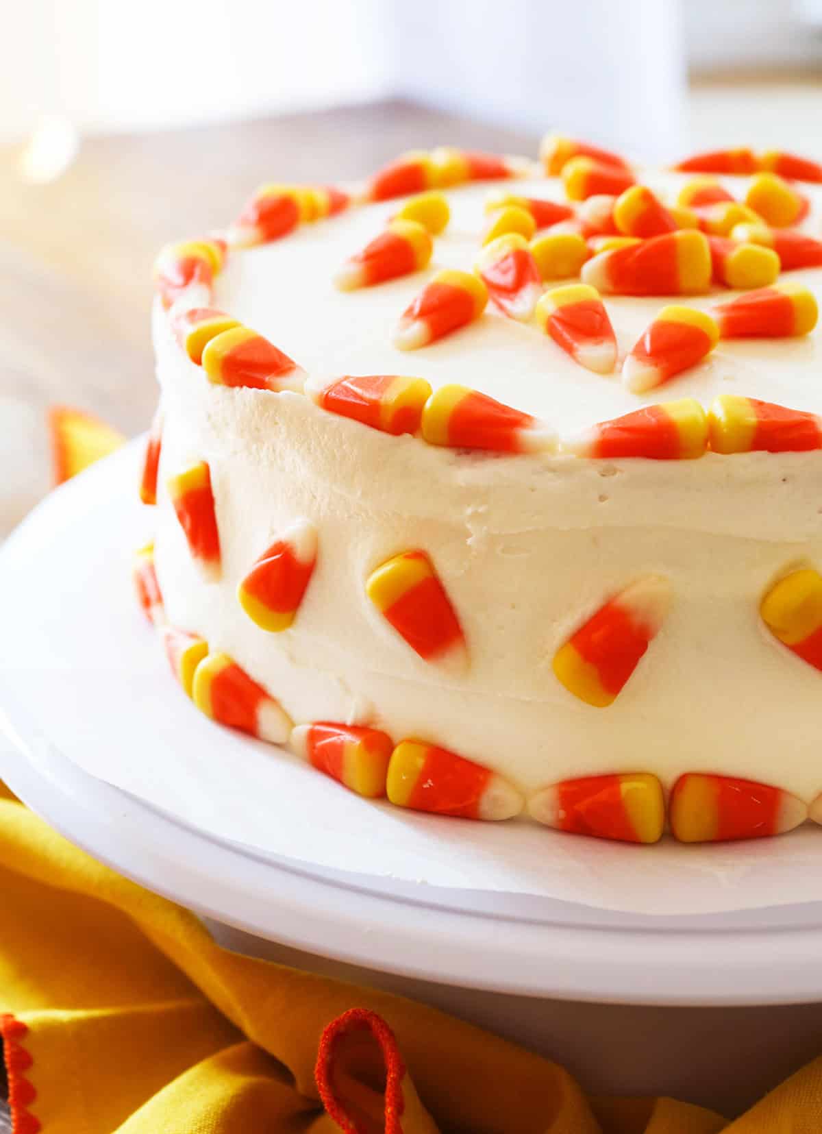 Festive Halloween candy corn cake with white frosting and candy corn decorations.