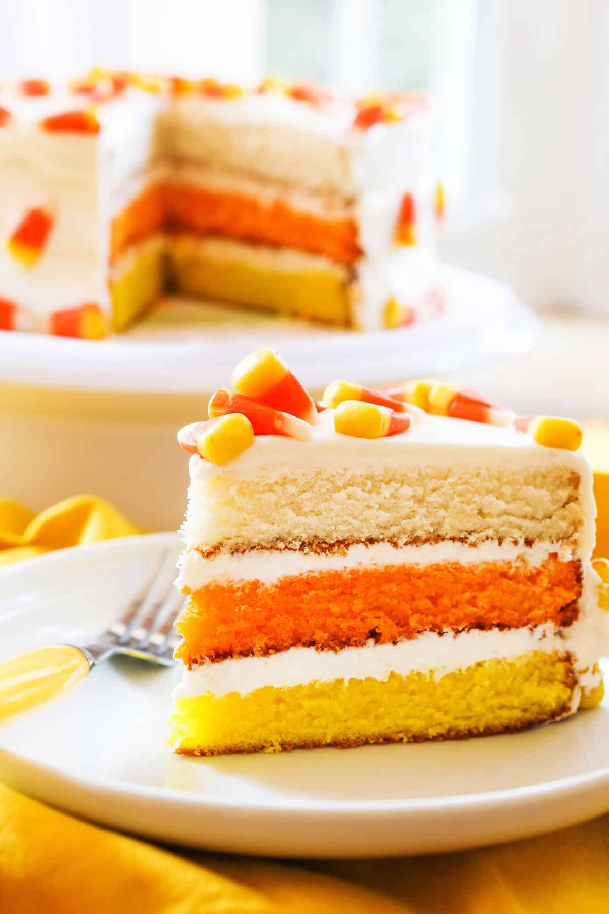 Festive candy corn layered cake with white, orange, and yellow layers.