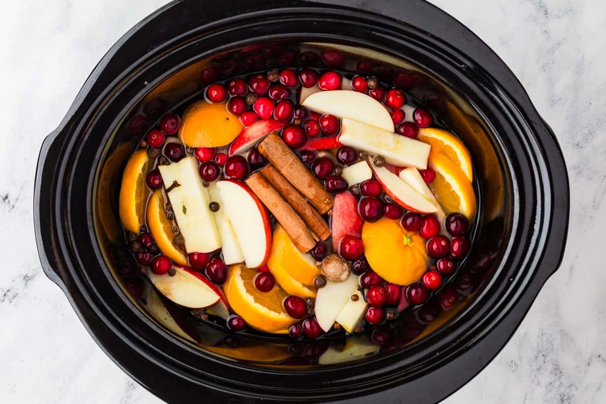 Top view of a slow cooker filled with a fall potpourri mixture.