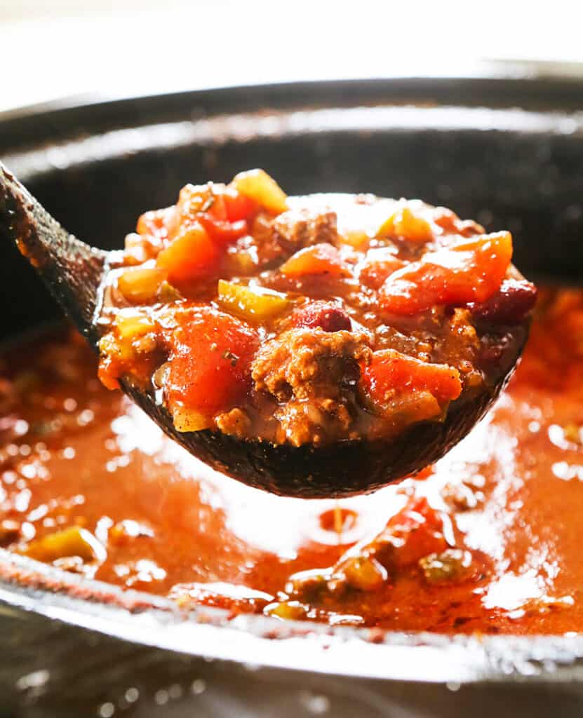 ladle of chili being lifted out of a pan
