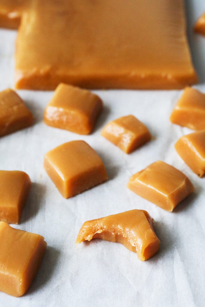 Lineup of homemade caramels with a bite taken out of one