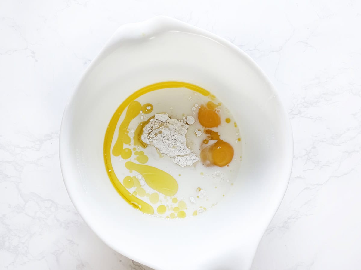 Ingredients for pancakes in a mixing bowl.