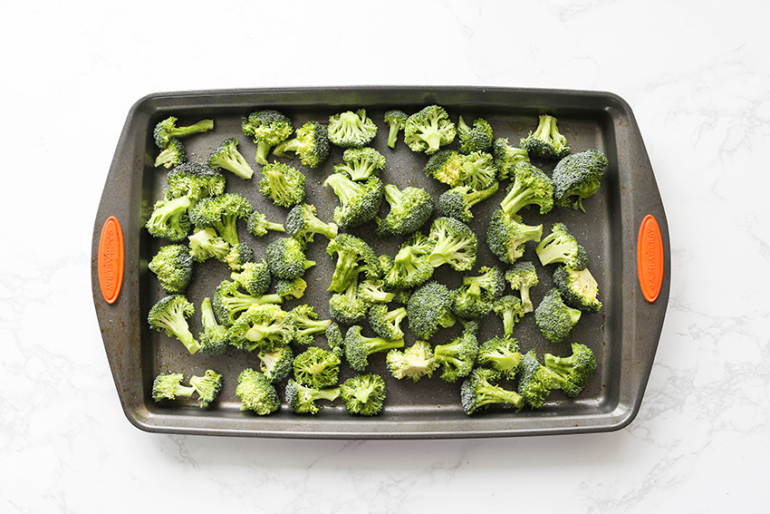 top view of a baking sheet filled with broccoli florets