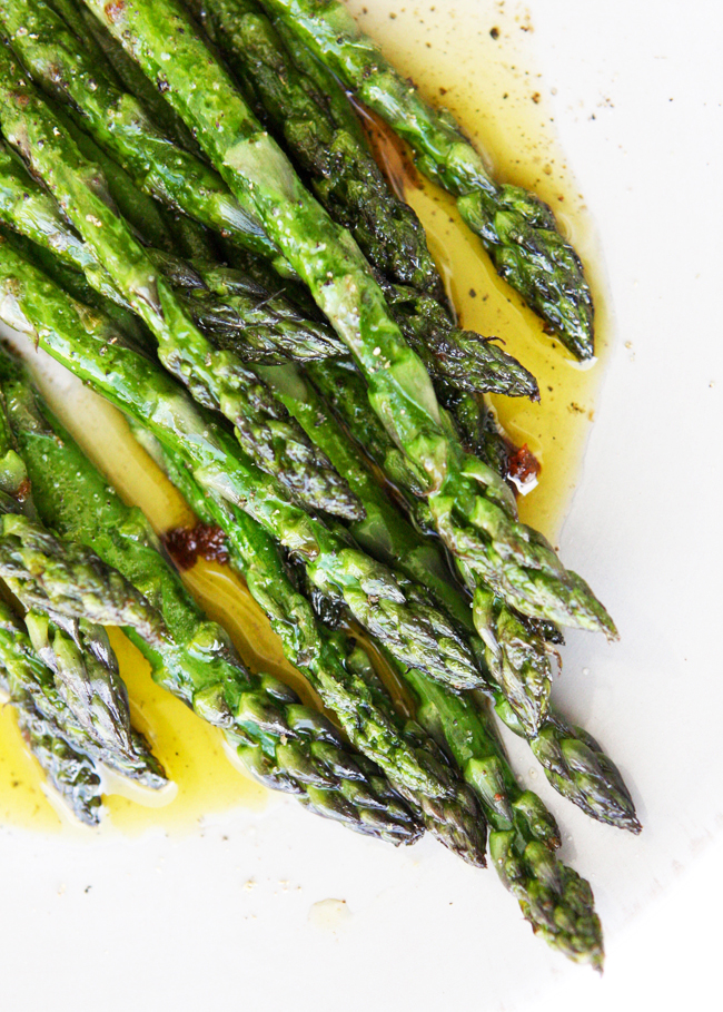 sauteed asparagus sitting in a serving dish with a little olive oil  underneath