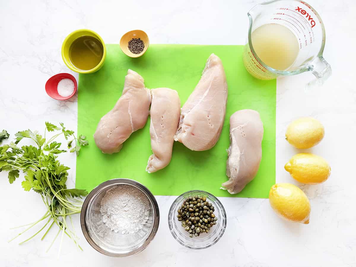 Ingredients for whole30 chicken piccata on a white counter.