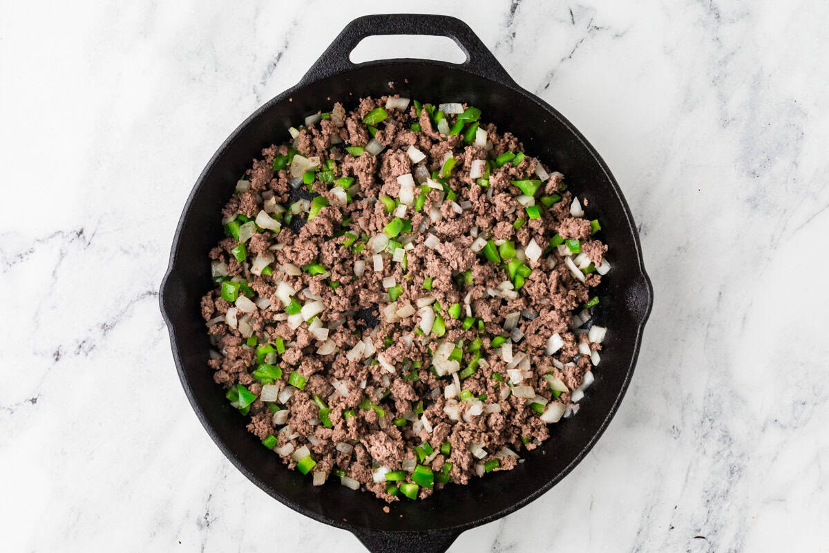 Cooked meat and veggie mixture in a pan.