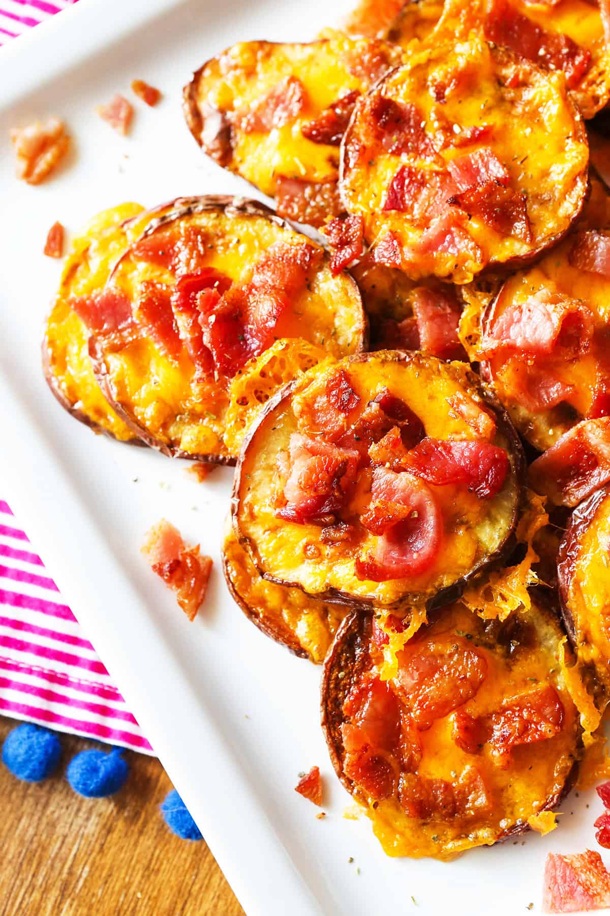 Looking down onto a plate with cheesy loaded baked potato rounds.