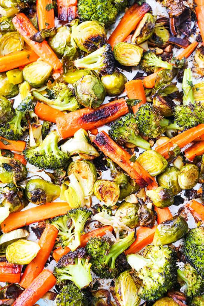 baking sheet filled with roasted vegetables: carrots, broccoli, brussels