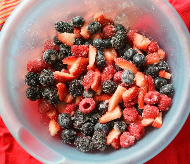 mixing bowl filled with berries and sugar