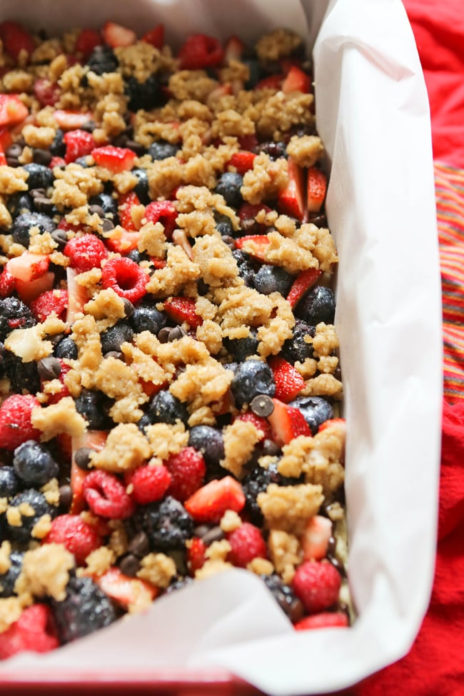 berries and crumbles in a baking pan lined with parchment before baking