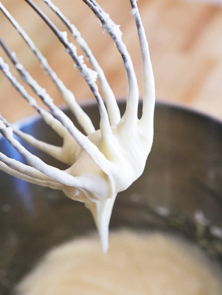 cream cheese frosting on a stand whisk