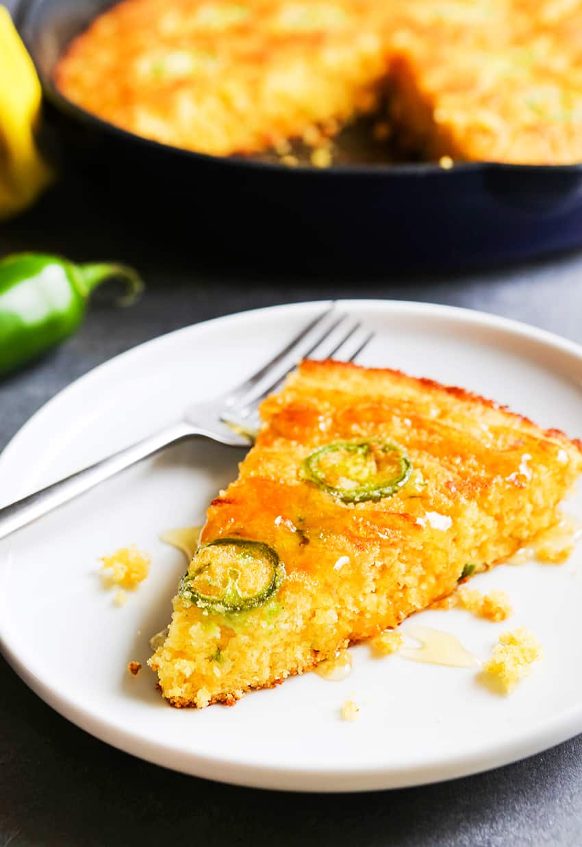 Slice of cornbread on a plate with a fork. 