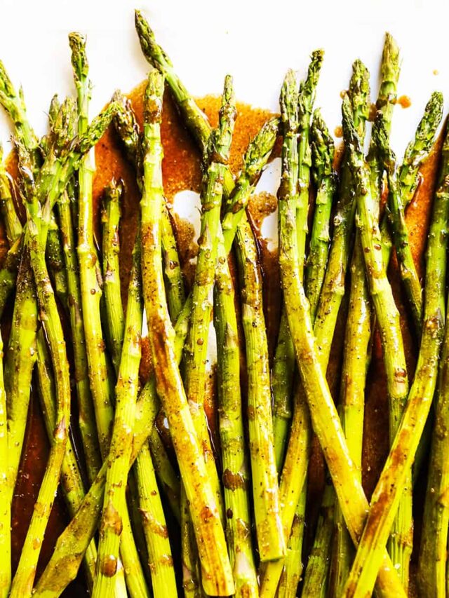 Baked asparagus with balsamic vinegar and butter on a serving plate. 