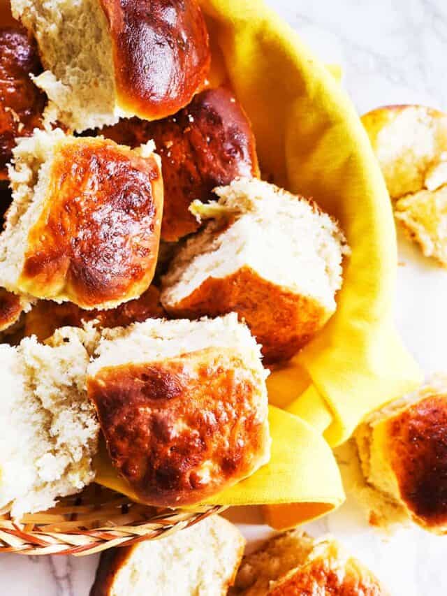 Dinner rolls in a towel lined basket. 