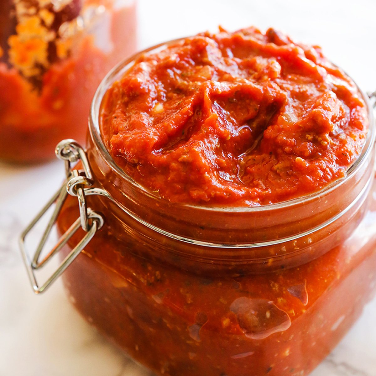 Mason jar overflowing with a thick red sauce.