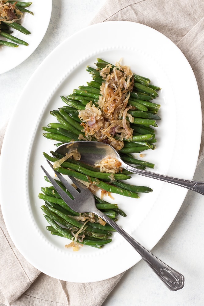 serving platter and serving forks with sauteed green beans and shallots