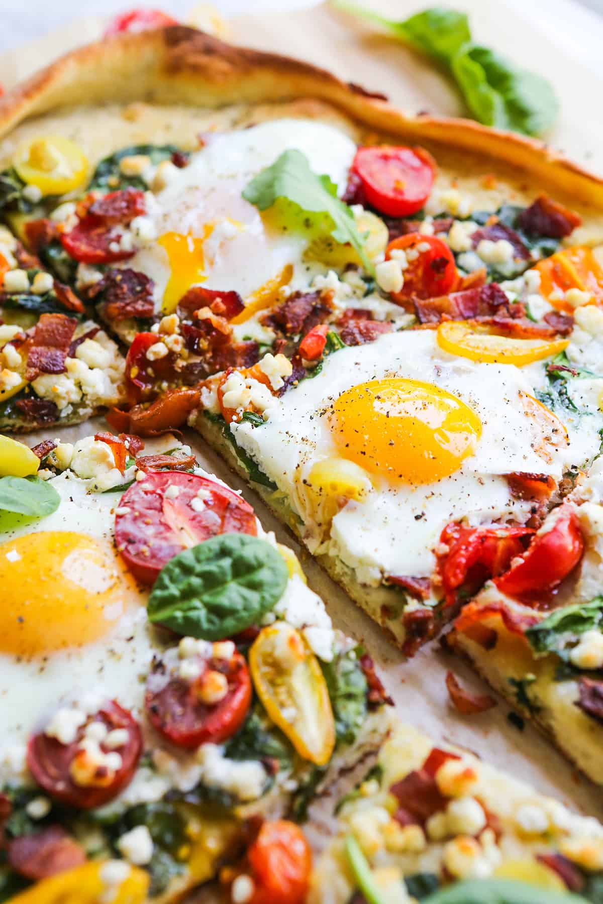 close up of cut pizza with eggs on top