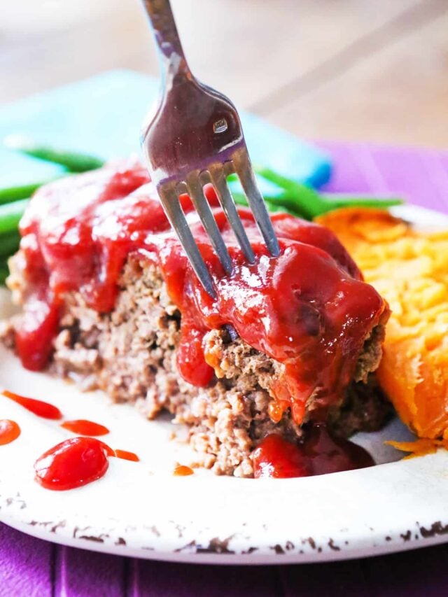 Fork being inserted into a piece of succulent meatloaf.