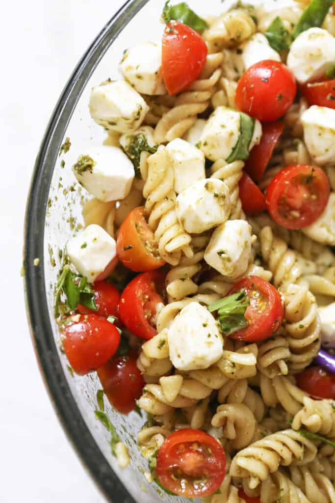 Caprese pasta salad in a glass bowl. 