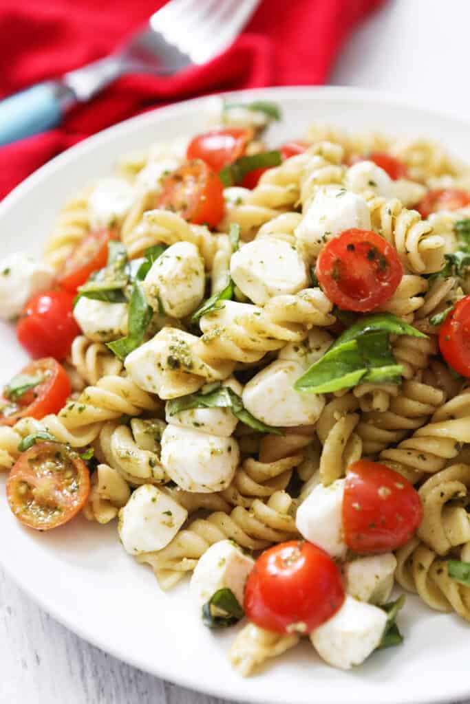 Plate with a serving of caprese pasta salad on it. 