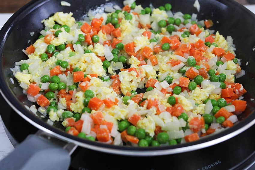 peas, carrots and eggs in a skillet