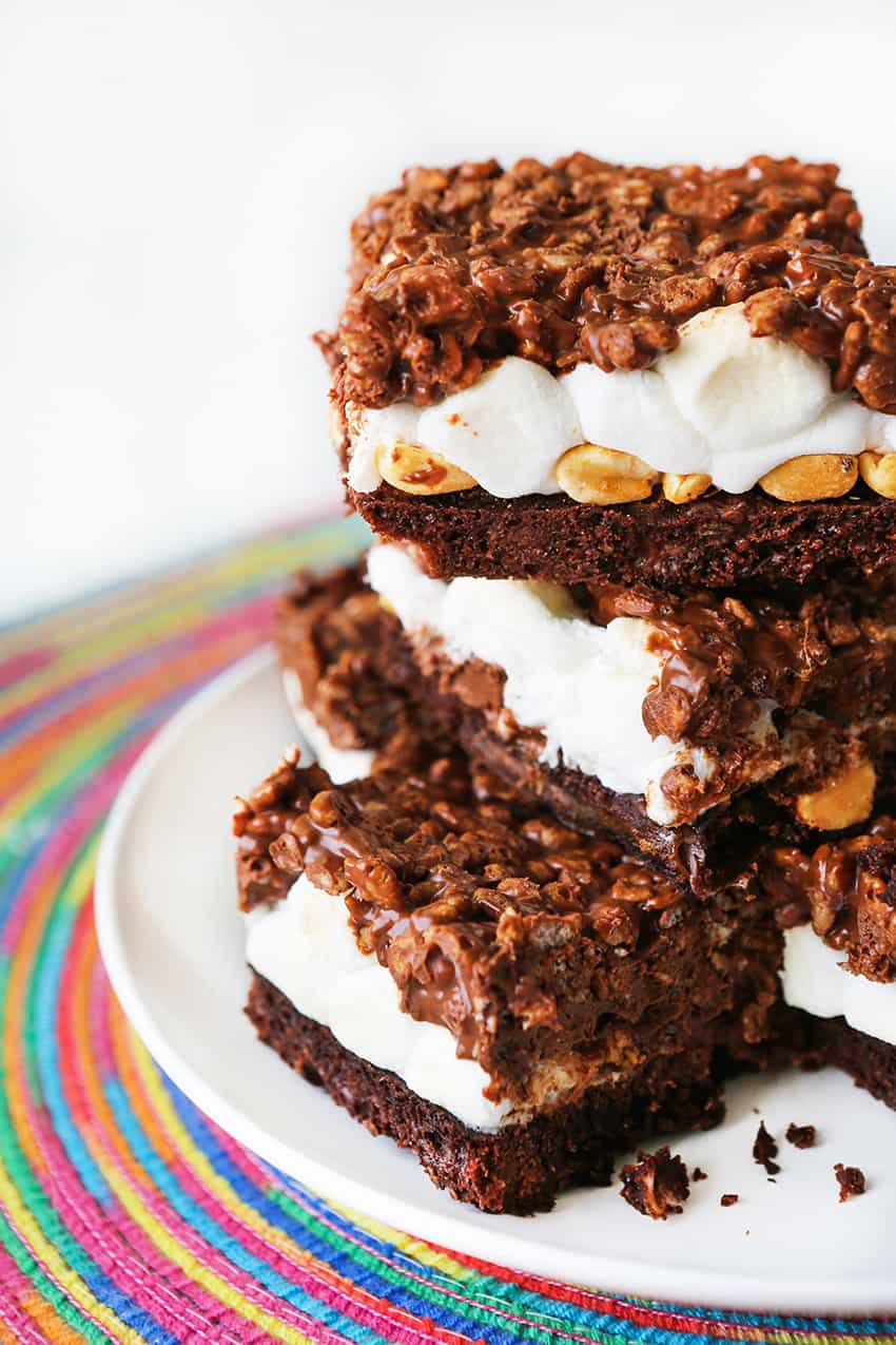 Brownies with marshmallows oozing out the sides stacked on top of one another.