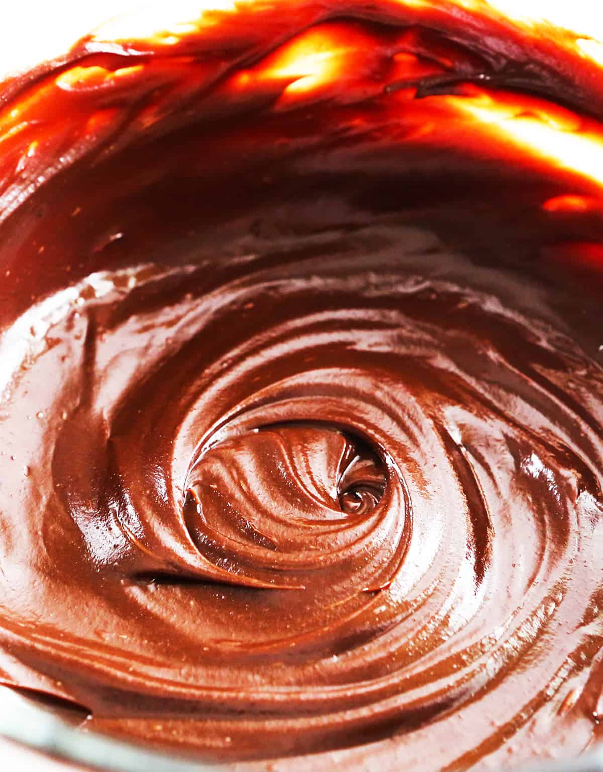 Whirlpool of dreamy, creamy chocolate ganache frosting swirled in a mixing bowl