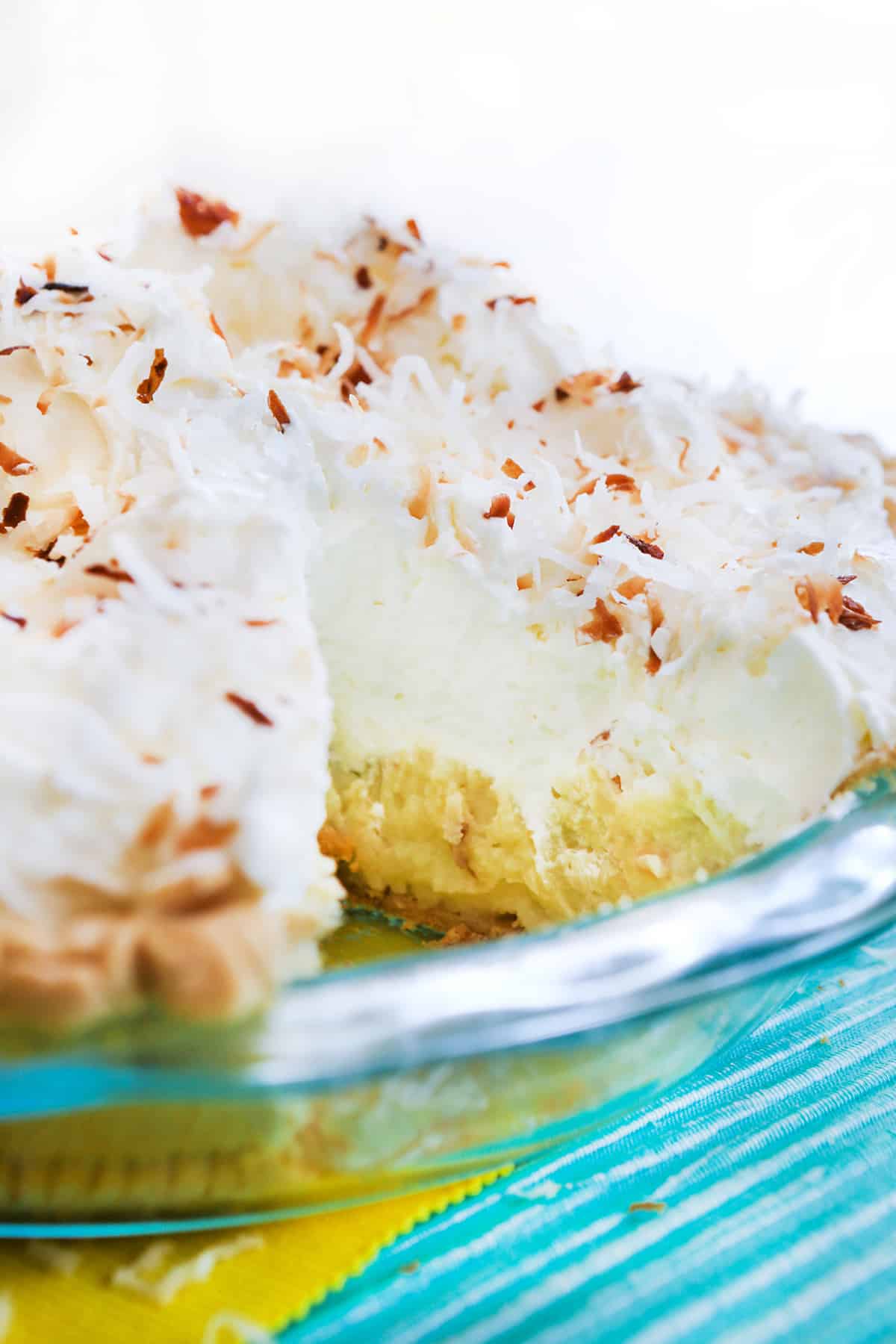 Coconut cream pie with a slice removed from dish.
