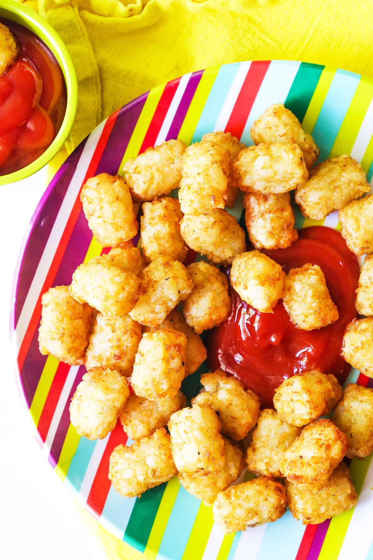 Plate filled with air fryer tater tots with ketchup in the center.