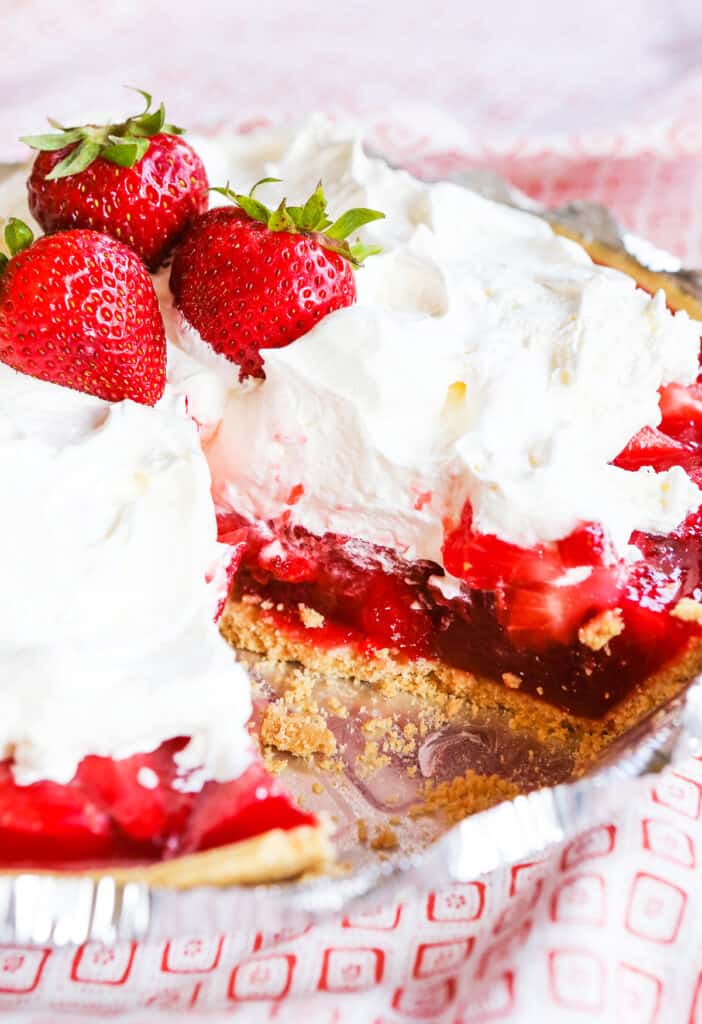 No bake strawberry pie topped with whipped cream and fresh strawberries.