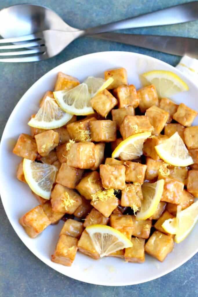 air fryer lemon tofu with quarter slices of lemon on a plate