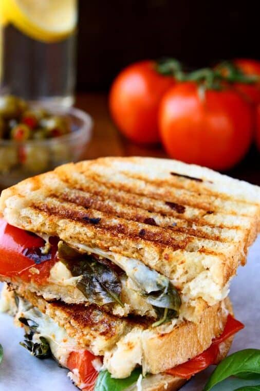 caprese panini sandwich cut in half on a plate