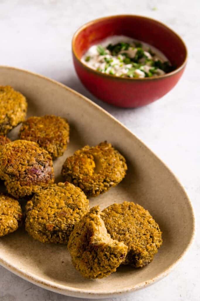 crispy vegan falafal served on a platter with tahini sauce in a bowl on the side