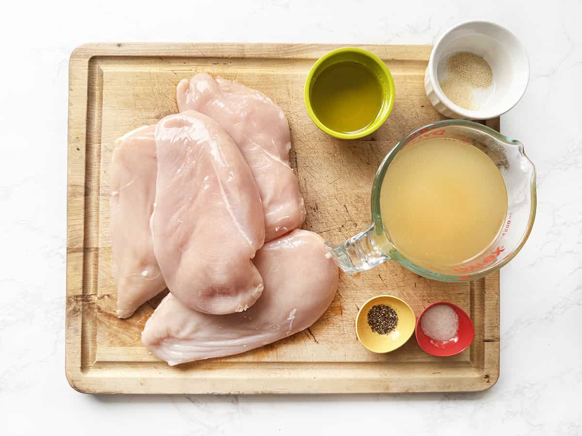 Cutting board filled with ingredients to make Instant Pot grilled chicken breasts.