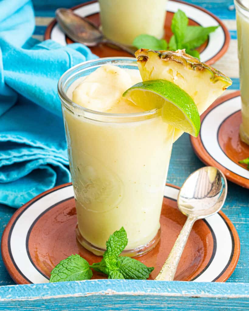 non alcoholic pina colada with lime and pineapple garnishes