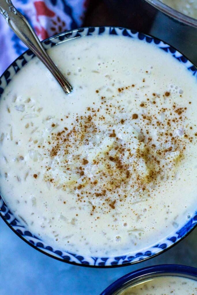 top view of a bowl full of arroz con leche and cinnamon sprinkled on top