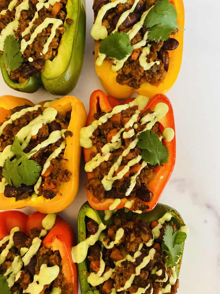 turkey taco stuffed peppers with a drizzle of avocado sauce over the tops