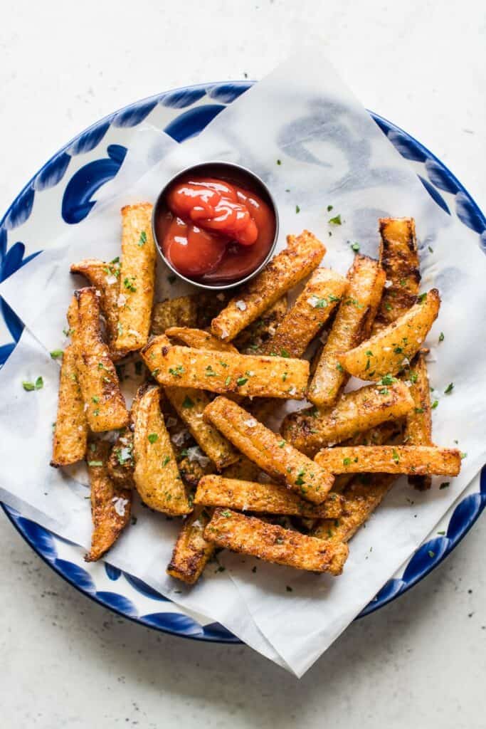 baked jicama fries on a plate with a saucer of ketchup