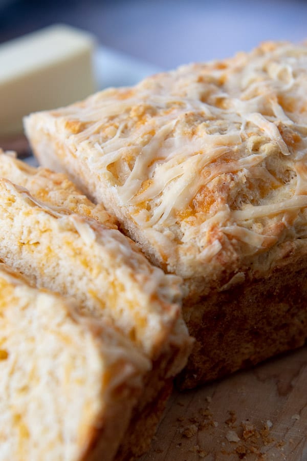 a loaf of quick cheese bread with a few slices cut into it