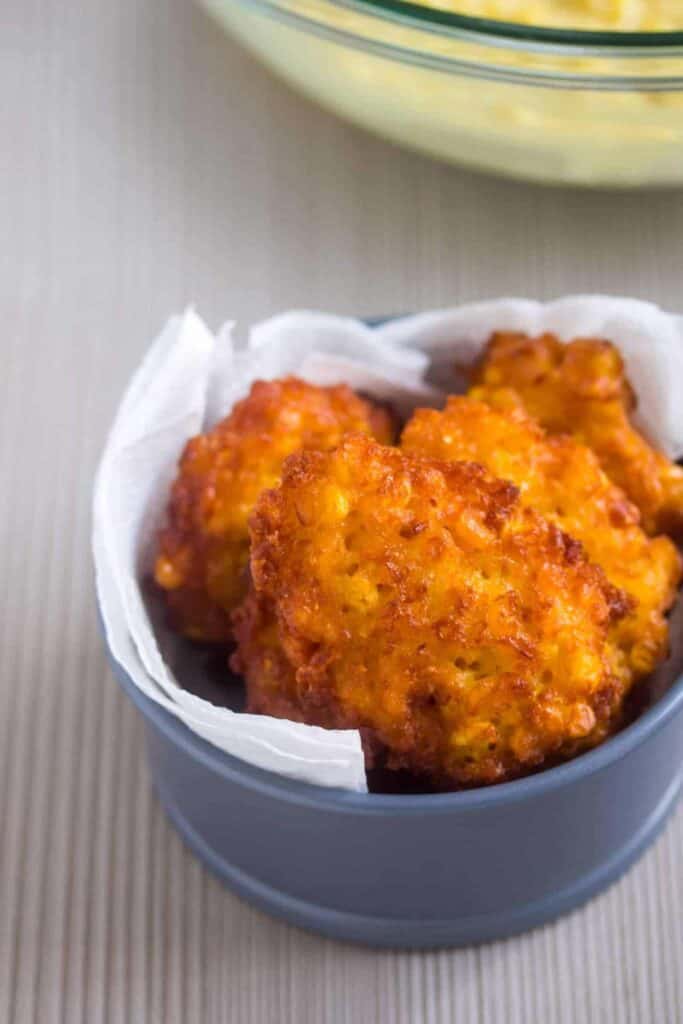 sweet corn fritters sitting in a papertowel sitting in a bowl