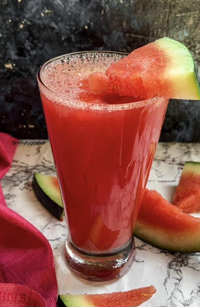 glass full of watermelon juice and a small slice as garnish on top