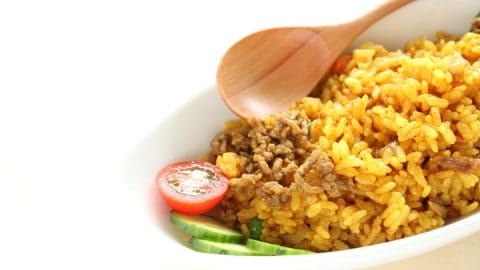 rice in a serving bowl with a wooden spoon alongside